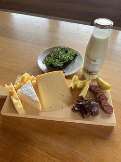 Frühstücksplatte mit hofeigenem Käse und Wurst sowie Milch 
