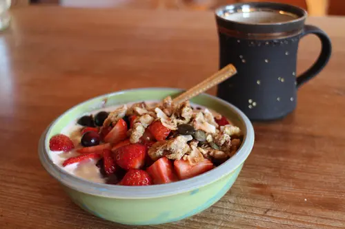 Porridge mit frischen Beeren und Kaffee